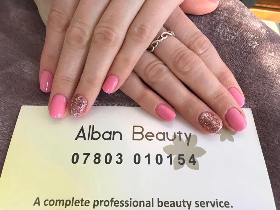 Pink gel nails with glitter accent at Alban Beauty